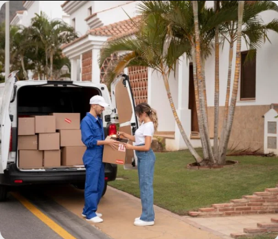 Two people standing outside with packing boxes. 