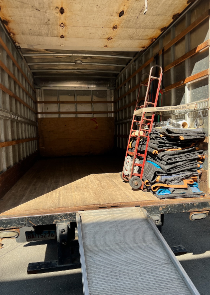  A large open container with pieces of clothes and more